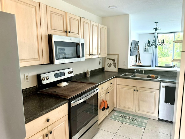 kitchen with light tile patterned flooring, a notable chandelier, kitchen peninsula, hanging light fixtures, and appliances with stainless steel finishes