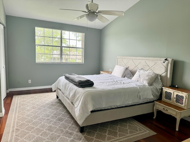 bedroom featuring ceiling fan, a closet, lofted ceiling, and dark wood-type flooring