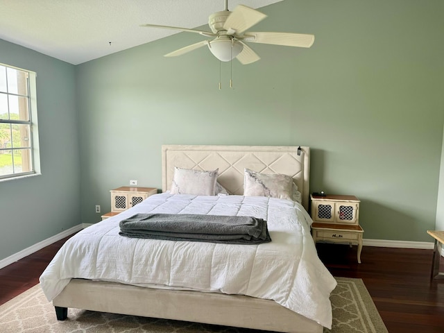 bedroom with ceiling fan, dark hardwood / wood-style floors, and vaulted ceiling