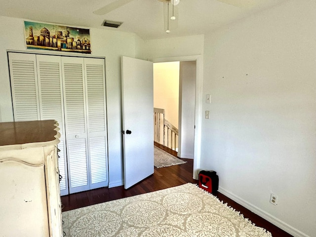 bedroom with ceiling fan, a closet, and dark wood-type flooring