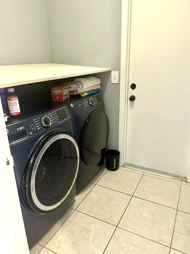 laundry area with light tile patterned floors and washer and dryer