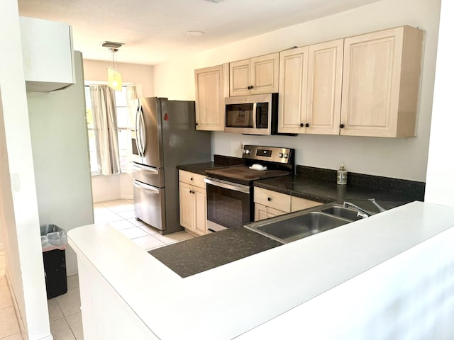 kitchen with light tile patterned floors, pendant lighting, stainless steel appliances, and sink