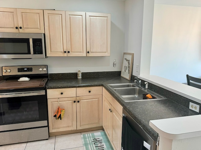 kitchen featuring light tile patterned floors, sink, kitchen peninsula, appliances with stainless steel finishes, and light brown cabinetry