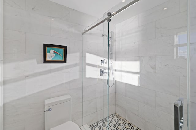 bathroom with a shower with door and toilet