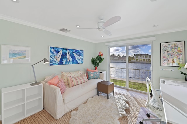 living room featuring light wood-type flooring, crown molding, a water view, and ceiling fan