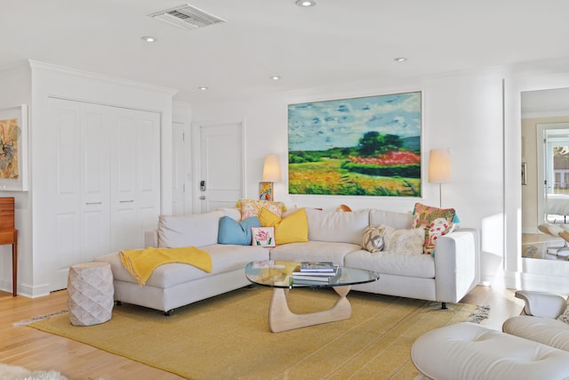 living room featuring ornamental molding and light hardwood / wood-style flooring