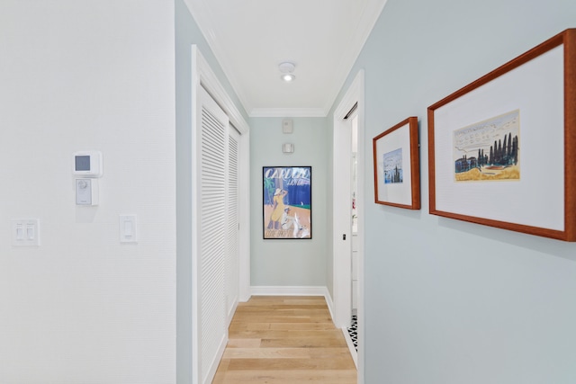 hall with ornamental molding and light hardwood / wood-style floors