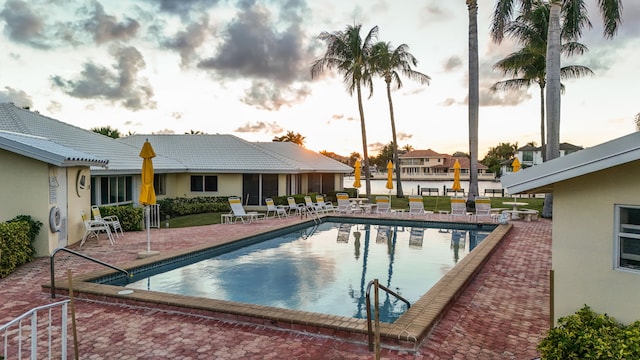 pool at dusk with a patio