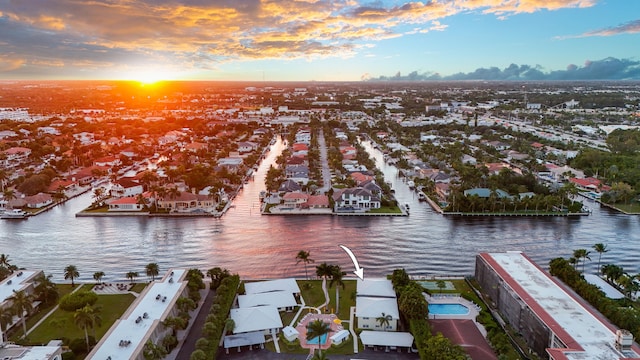 aerial view at dusk featuring a water view