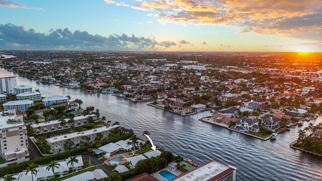 aerial view at dusk featuring a water view