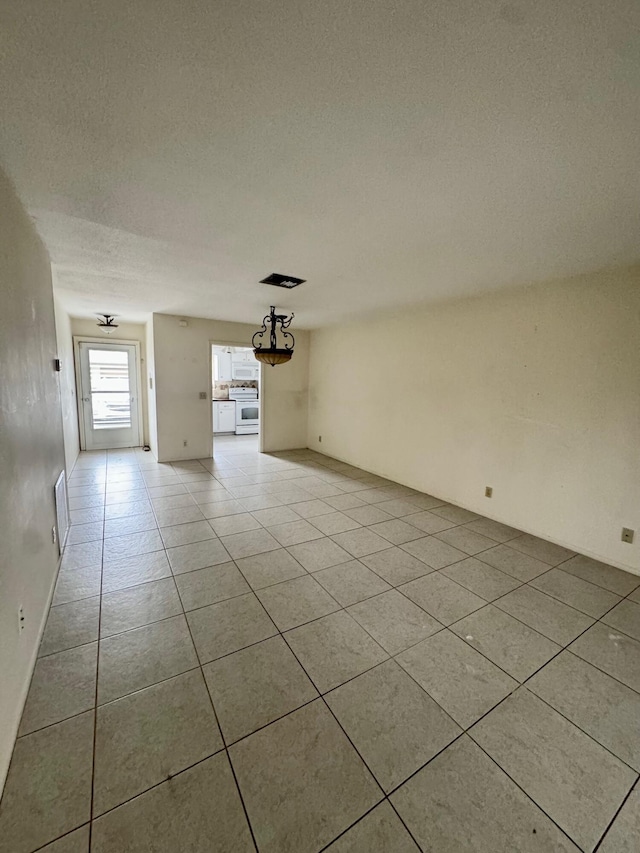 unfurnished living room with light tile patterned floors and a textured ceiling