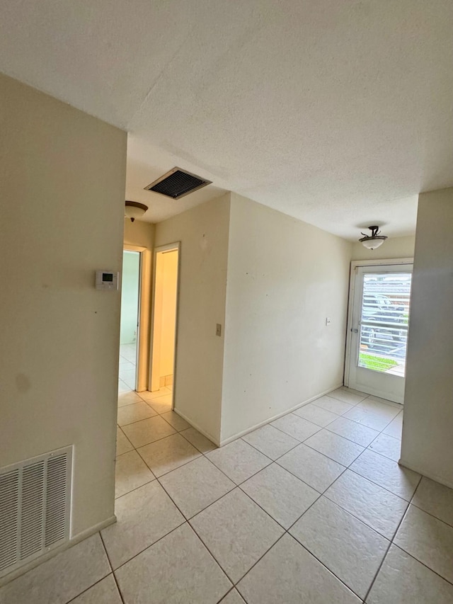 tiled spare room with a textured ceiling