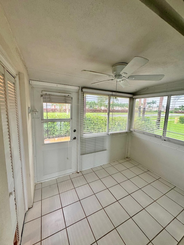 unfurnished sunroom with plenty of natural light and a ceiling fan