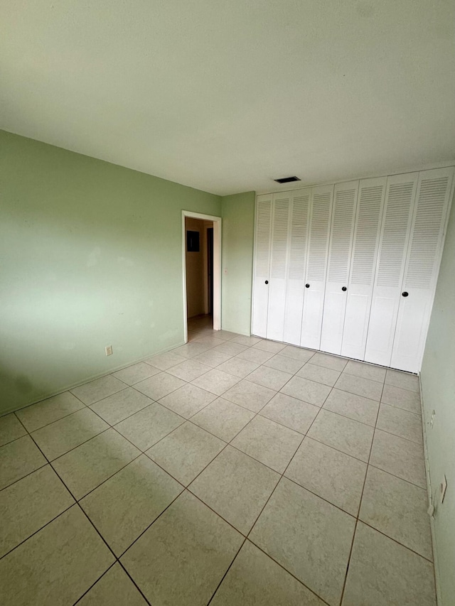 unfurnished bedroom featuring visible vents and light tile patterned floors