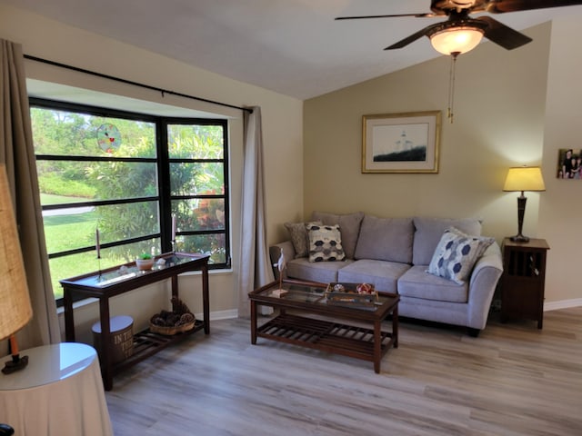 living room featuring lofted ceiling, a ceiling fan, light wood-style floors, and baseboards