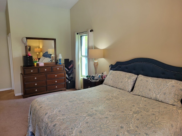 carpeted bedroom with high vaulted ceiling