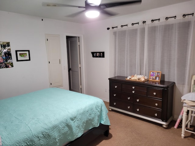 bedroom with a ceiling fan and light carpet