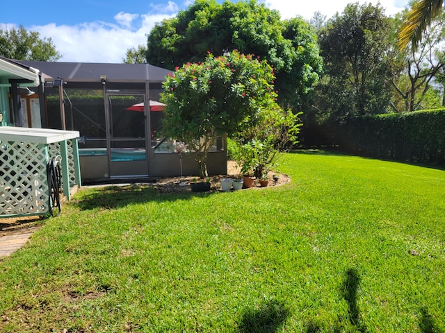 view of yard with glass enclosure and a fenced in pool