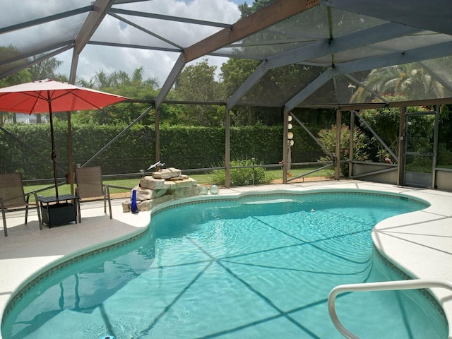 pool featuring glass enclosure and a patio