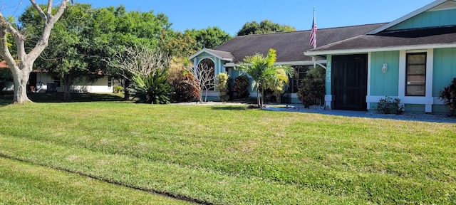 view of front of home featuring a shingled roof and a front lawn