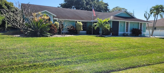 view of front facade with a front lawn and fence