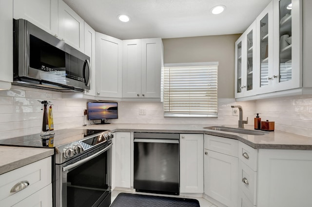 kitchen with stainless steel appliances, backsplash, and white cabinets