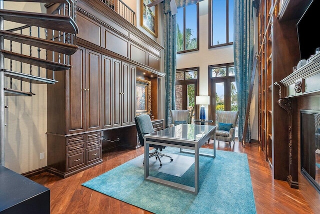 office area with wood-type flooring and a high ceiling