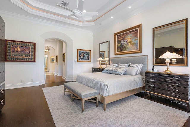 bedroom featuring ornamental molding, a raised ceiling, dark hardwood / wood-style flooring, and ceiling fan