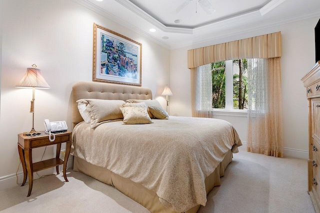 carpeted bedroom with ceiling fan, a raised ceiling, and ornamental molding