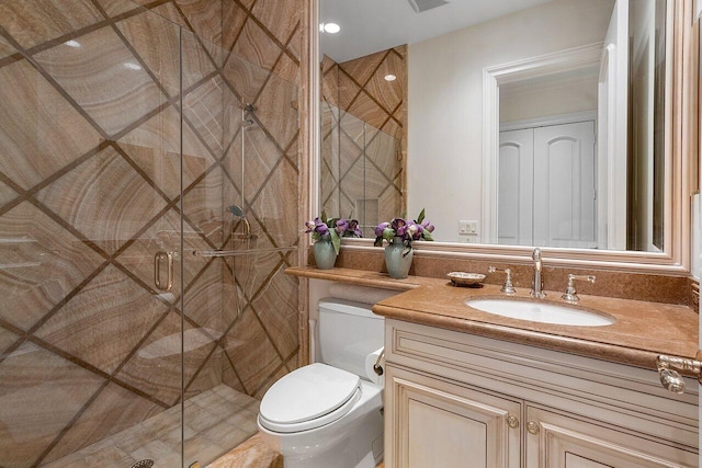 bathroom featuring vanity, toilet, and a shower with door