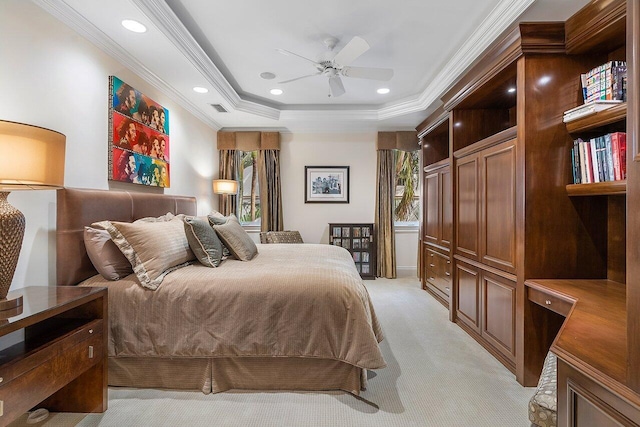 carpeted bedroom featuring multiple windows, ceiling fan, a tray ceiling, and ornamental molding