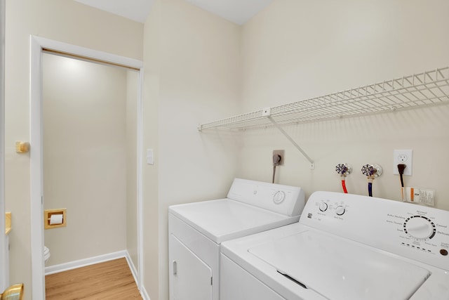 washroom with light hardwood / wood-style floors and washing machine and clothes dryer