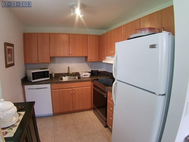 kitchen featuring sink, white appliances, and light tile patterned flooring