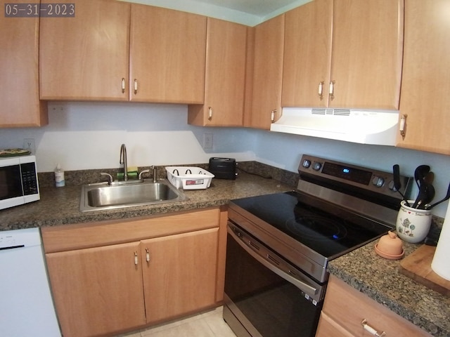 kitchen with sink, white appliances, and dark stone counters