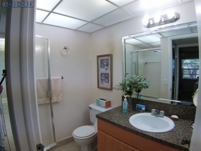 bathroom with vanity, a paneled ceiling, an enclosed shower, and toilet