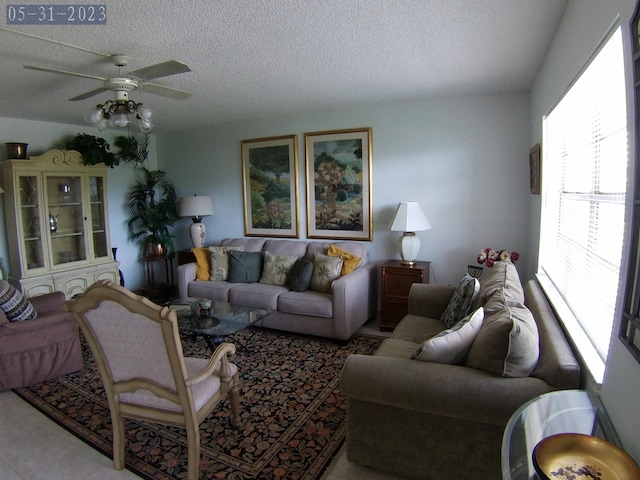 living room with ceiling fan and a textured ceiling