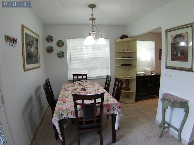 tiled dining room featuring a textured ceiling