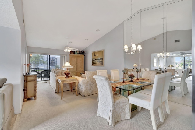 carpeted dining space featuring high vaulted ceiling and ceiling fan