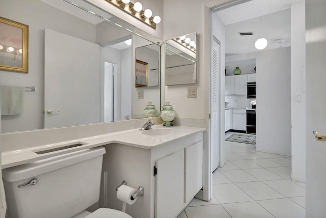 bathroom featuring vanity, tile patterned floors, and toilet