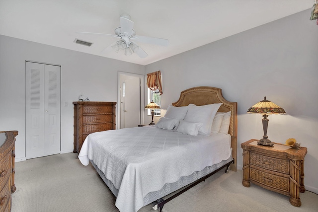 carpeted bedroom with a closet, visible vents, baseboards, and ceiling fan