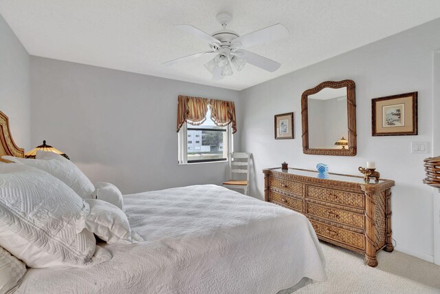 carpeted bedroom with a textured ceiling and ceiling fan