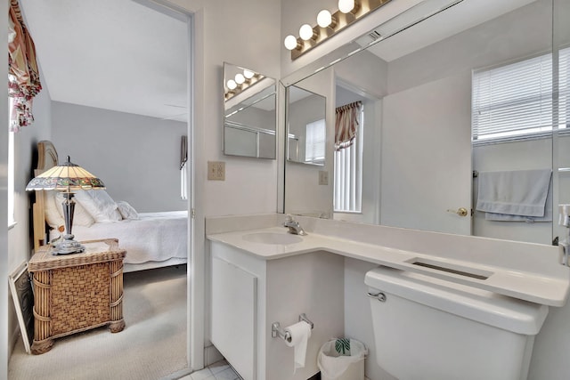 bathroom featuring toilet, ensuite bath, and vanity