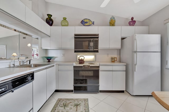 kitchen with white appliances, vaulted ceiling, light countertops, and a sink