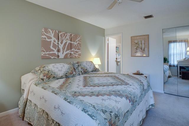 carpeted bedroom featuring ceiling fan and a closet