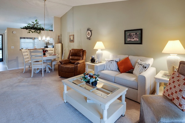 living room with lofted ceiling, an inviting chandelier, and light carpet