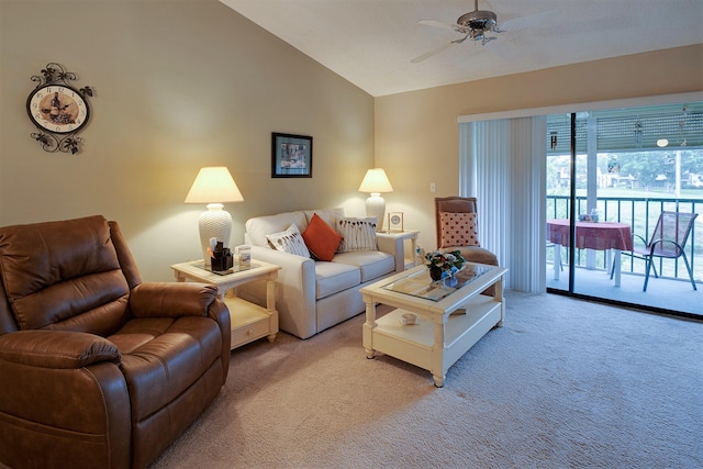 carpeted living room with ceiling fan and vaulted ceiling