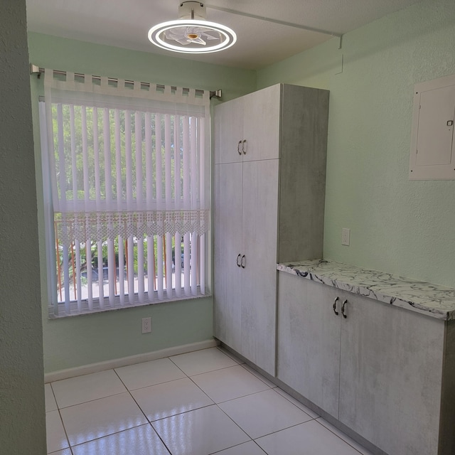 interior space featuring light tile patterned floors and electric panel