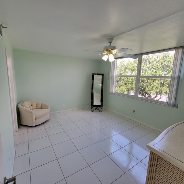 unfurnished room with ceiling fan and light tile patterned floors