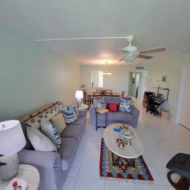 living room featuring ceiling fan with notable chandelier and light tile patterned floors