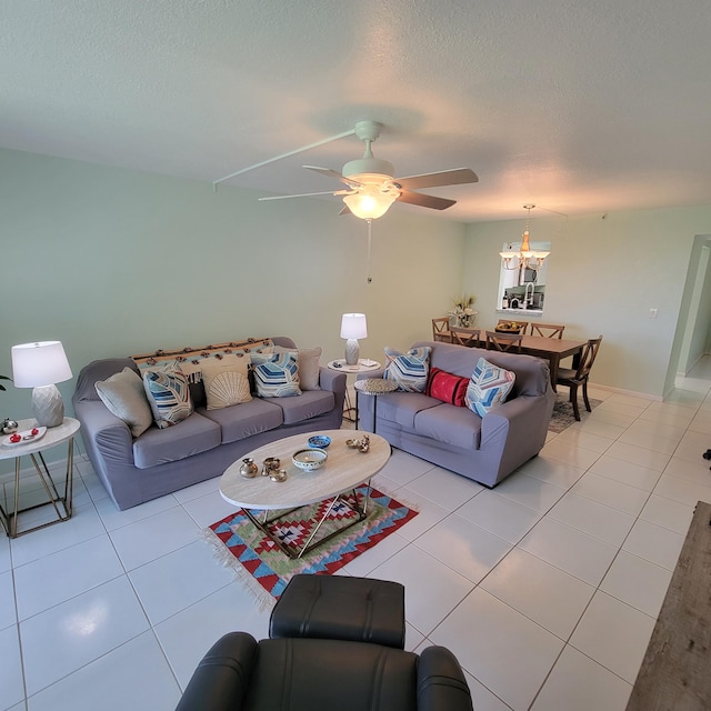 living room featuring ceiling fan with notable chandelier, a textured ceiling, and light tile patterned floors